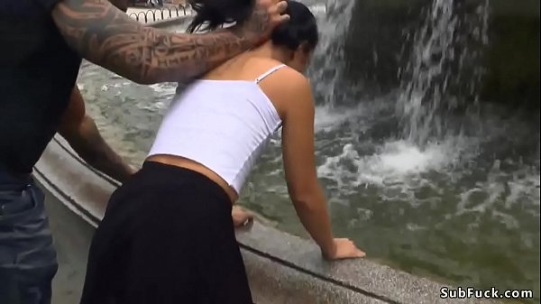 Slender black-haired moist at public fountain